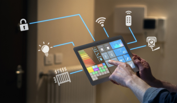 Two hands holding a tablet device showing a home energy management console.